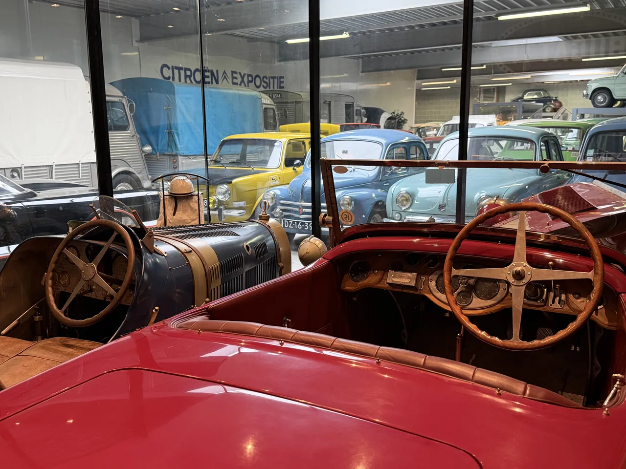 Historische open auto's met andere klassiekers op de achtergrond in het museum